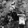 two adults helping a child rockclimb